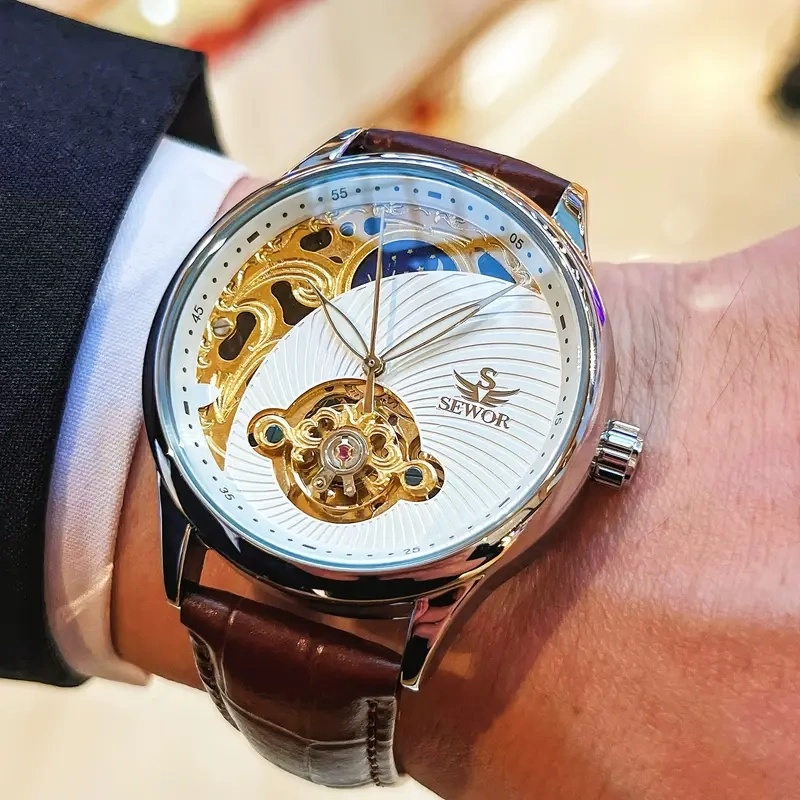 Luxury Watch Makes - 豪華なメンズ自動巻き機械式腕時計。エレガントさとファッション性を兼ね備えたスケルトンデザイン。スケルトン・トゥールビヨンとハーフムーンデザインを採用し、休日やビジネスの集まりに最適な贈り物。レトロでありながらファッショナブルなビジネス美学を示しています。 それは、豪華でスタイリッシュ、シンプルでカジュアル、多用途でユニークな男性用トゥールビヨン腕時計で、レトロなスタイル、夜光機能、防水機能を備え、小さなゴールドデザインが特徴です。 それはファッショナブルなアクセサリーであり、彼への最高の贈り物です。